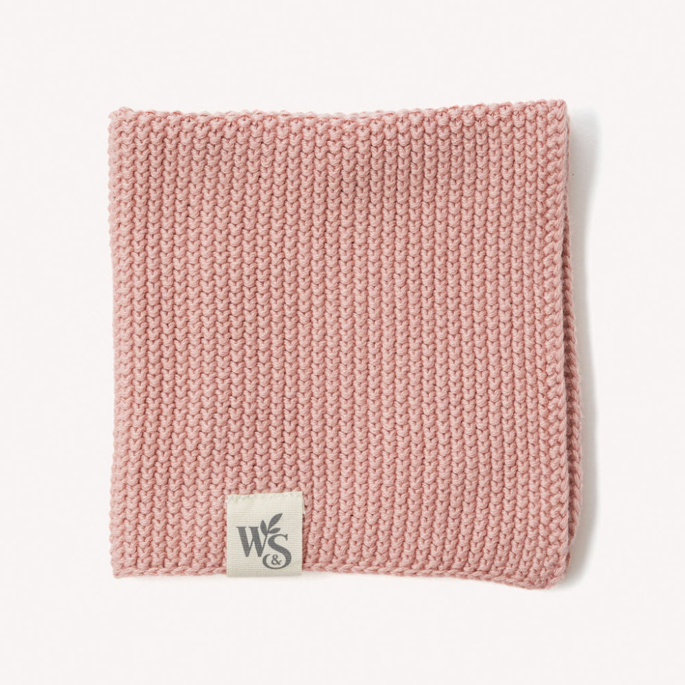 Pink knitted organic dishcloth with a logo on a white background
