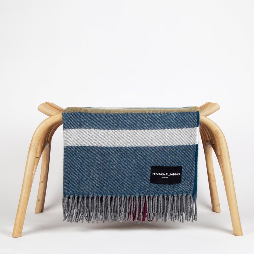 Plaid blanket draped over a wooden chair on a white background