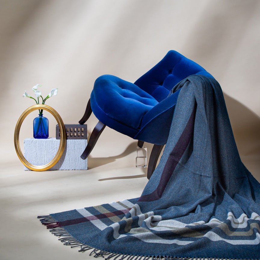 Blue plaid blanket draped over a chair with decorative items on a neutral background