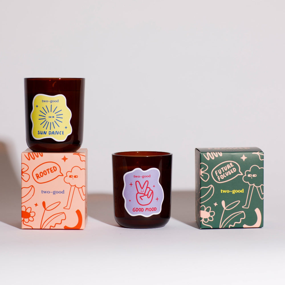 Two candles with decorative packaging on a white background