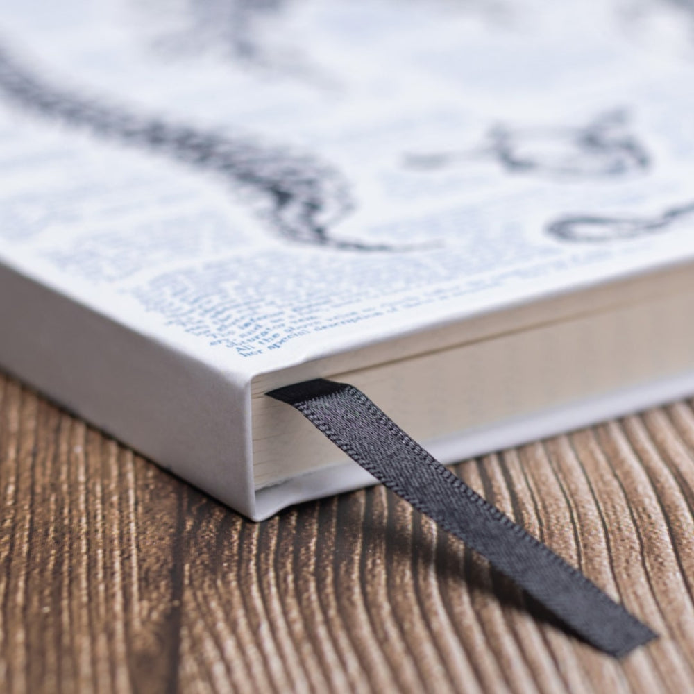 A5 Anatomy Notebook with a black ribbon bookmark on a wooden surface