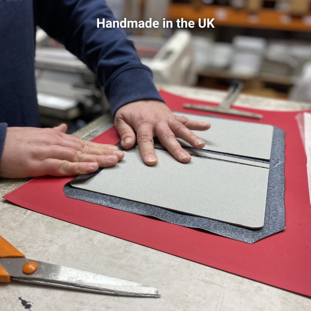 Person working with notebook on a table with 'Handmade in the UK' text.