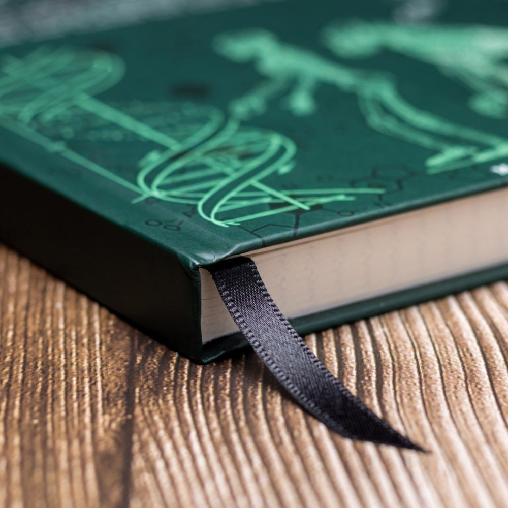 Green notebook of evolution and genetics with a black ribbon bookmark on a wooden surface