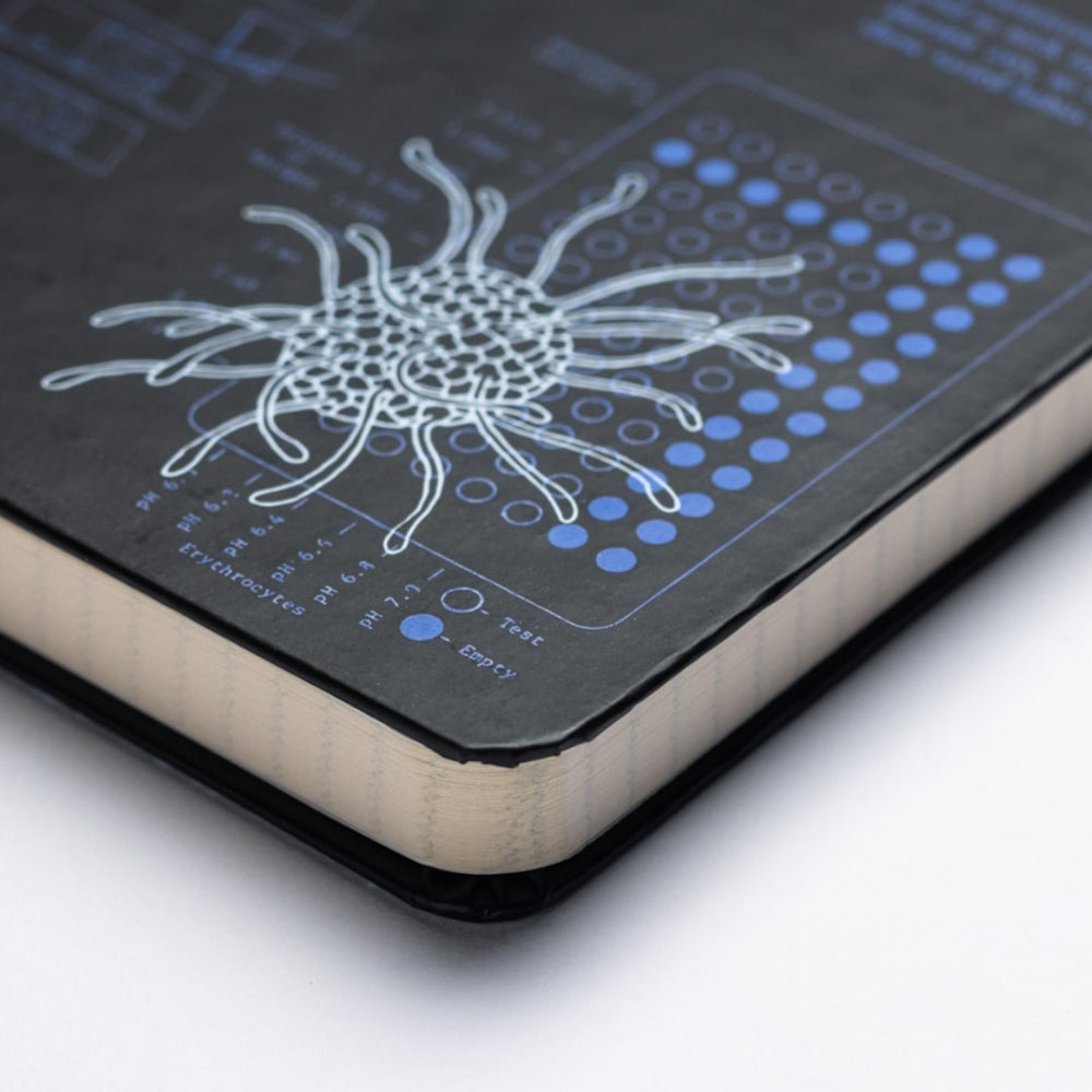 Close-up of a notebook with a microbiology illustration and blue dots on a dark cover