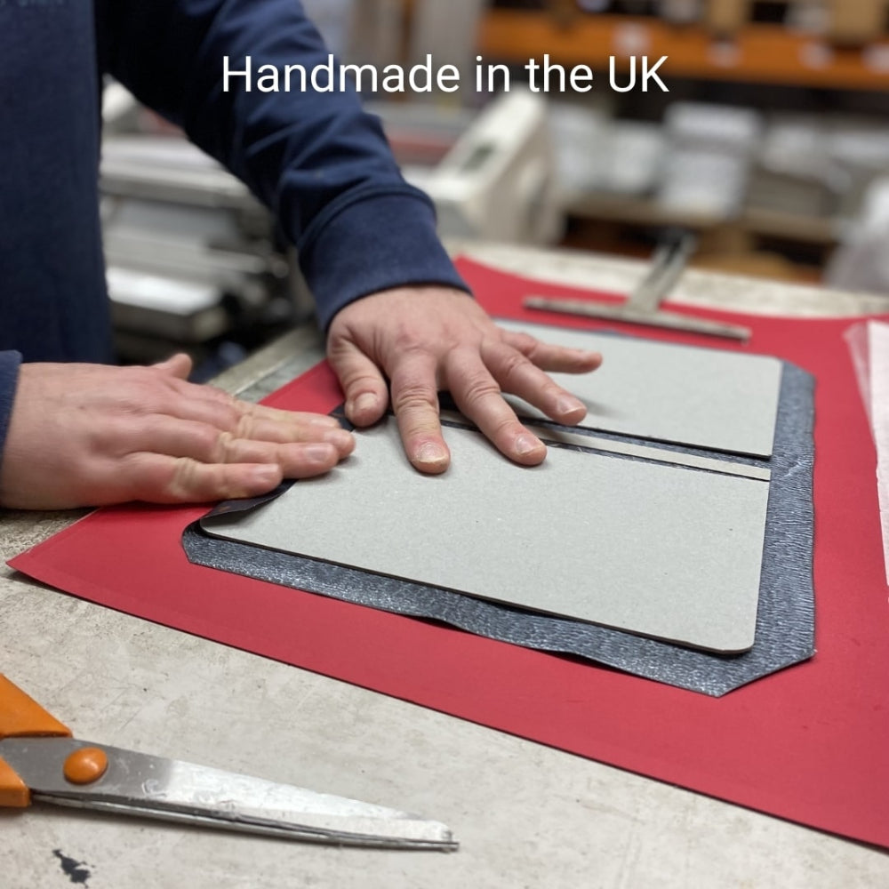 Person working with notebook on a table with 'Handmade in the UK' text.