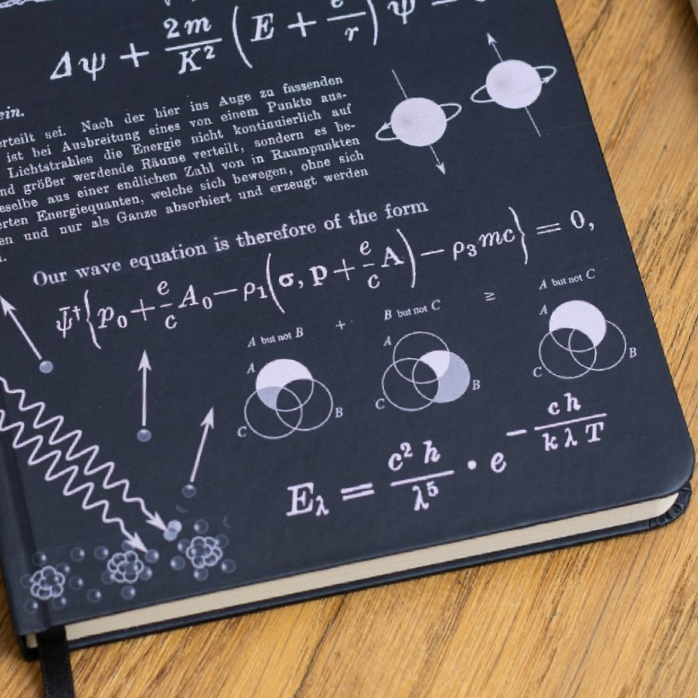 A5 Notebook with Quantum Physics scientific equations and diagrams on a wooden surface