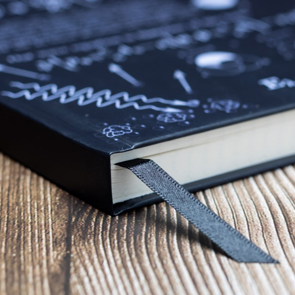 Close-up of a dark blue notebook with white text on a wooden surface