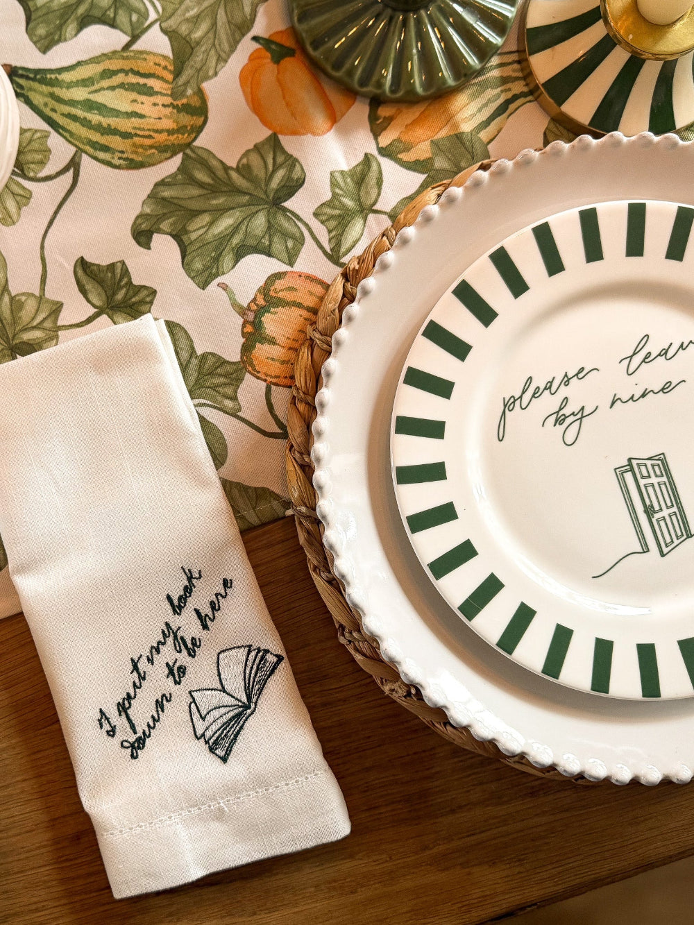 Table setting with a decorative plate and napkin featuring text and graphics.