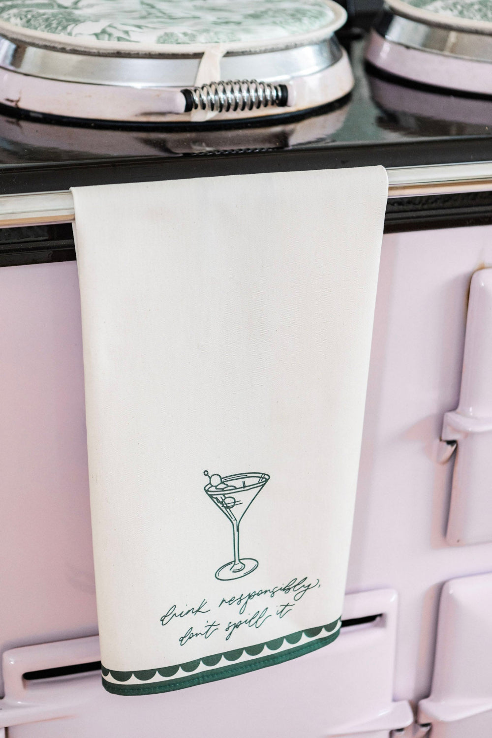 Tea towel with martini graphic and text on a stove