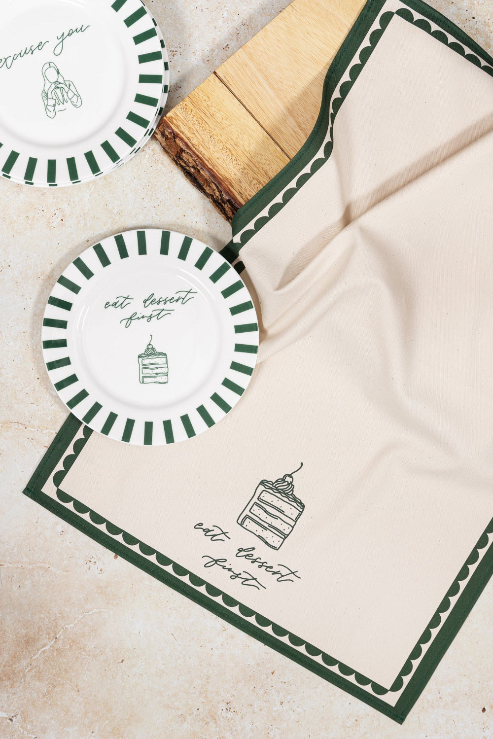 Set of plates and napkins with green and white designs on a neutral background
