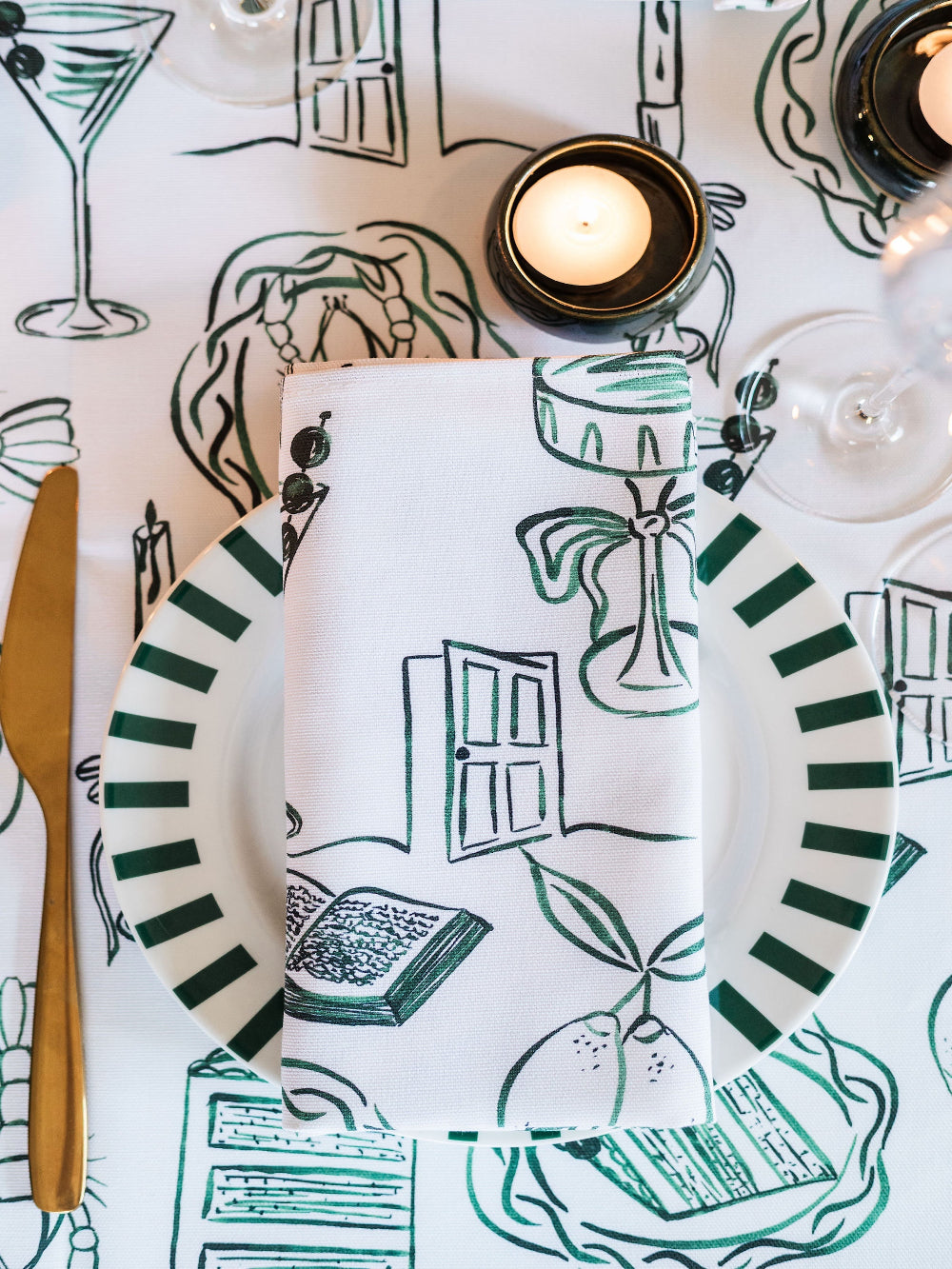 Table setting with plates, napkin, and cutlery on a decorative tablecloth.