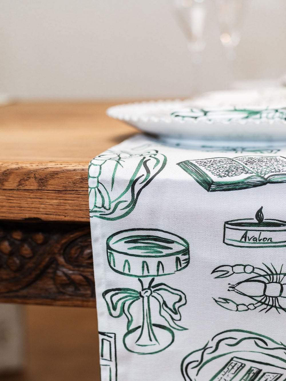 Table runner with green designs on a wooden table