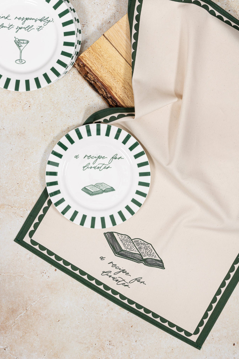 Bone china plate with green and white stripes text 'recipe for disaster' on a beige matching text tea towel