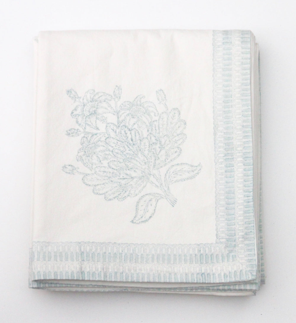 Folded tablecloth with floral embroidery on a white background