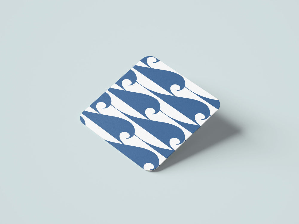 Blue and white ocean wave patterned coaster on a light grey background