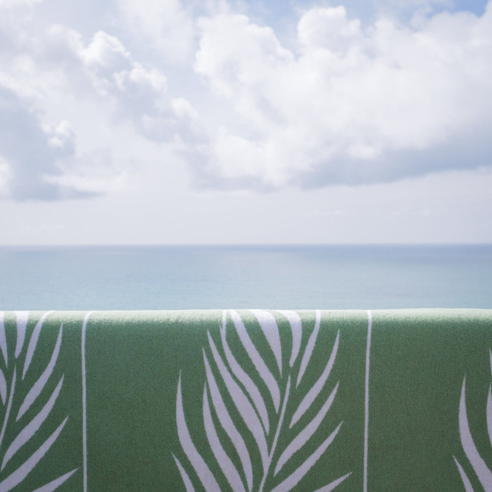 Botanical Palm Blanket with white leaf pattern against a blue sky