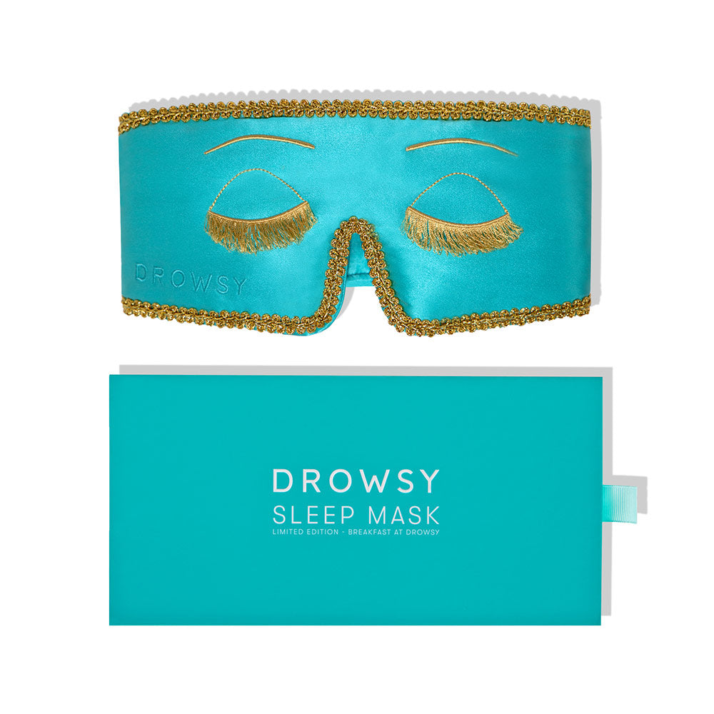 Breakfast at Tiffany's inspired sleep mask with gold accents and packaging on a white background