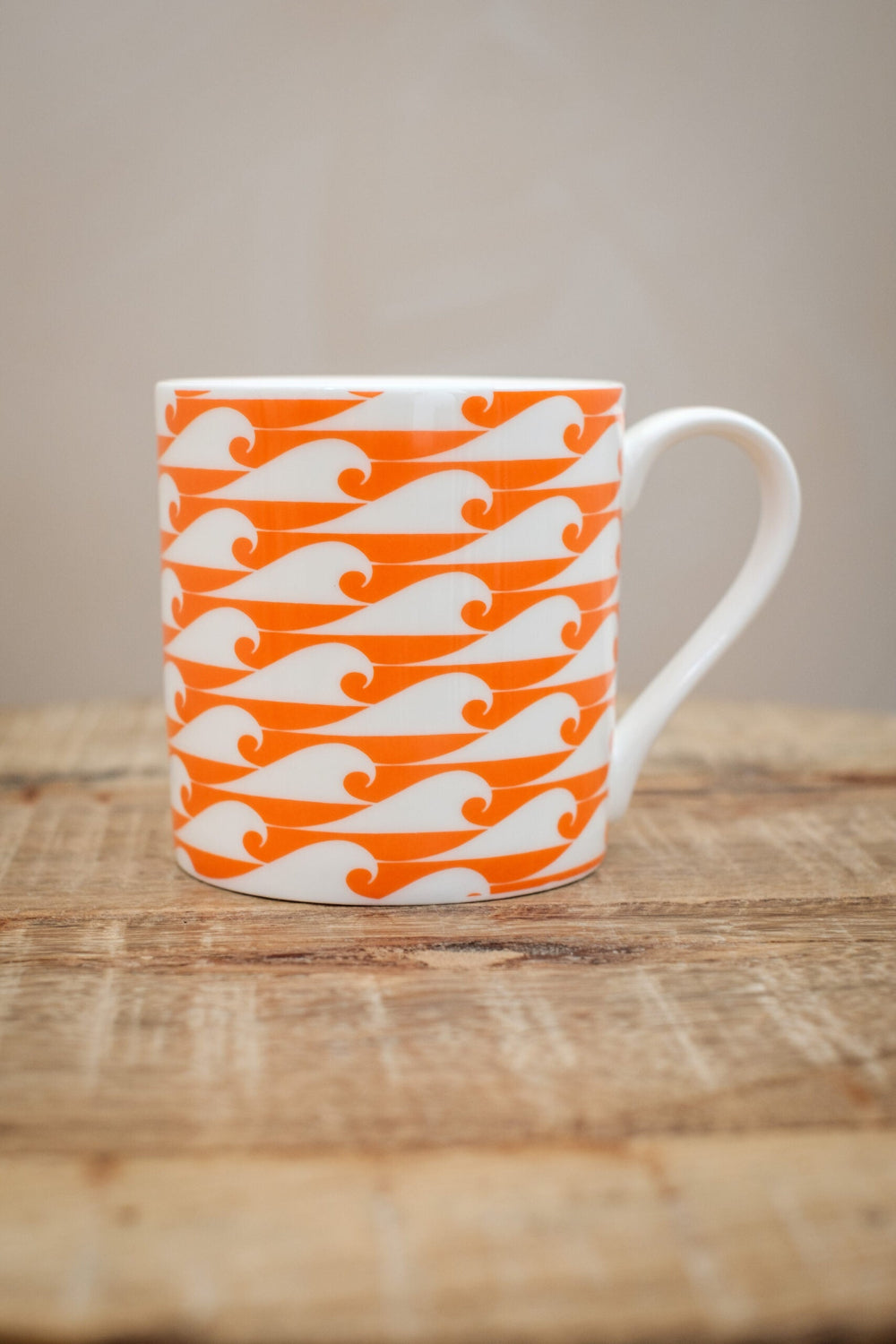 Campervan coloured wave mug with white on a wooden table