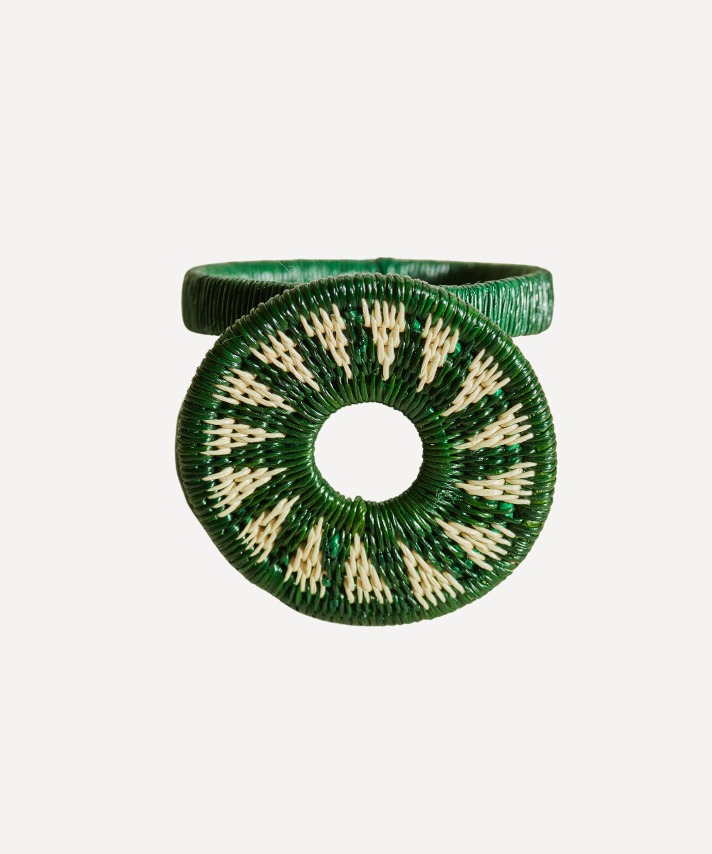 Green and beige circular woven napkin ring on a white background