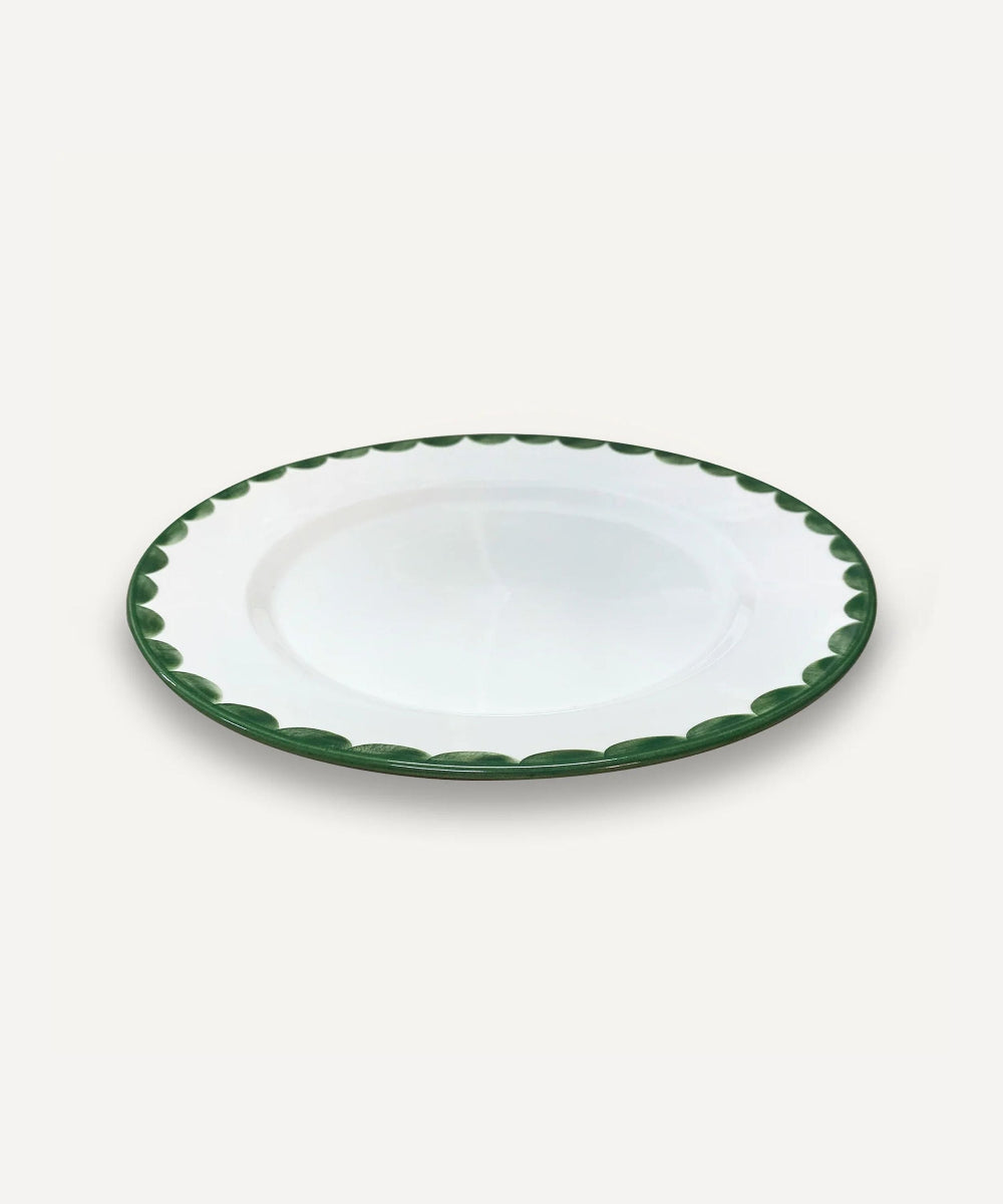 White ceramic plate with green rim on a white background