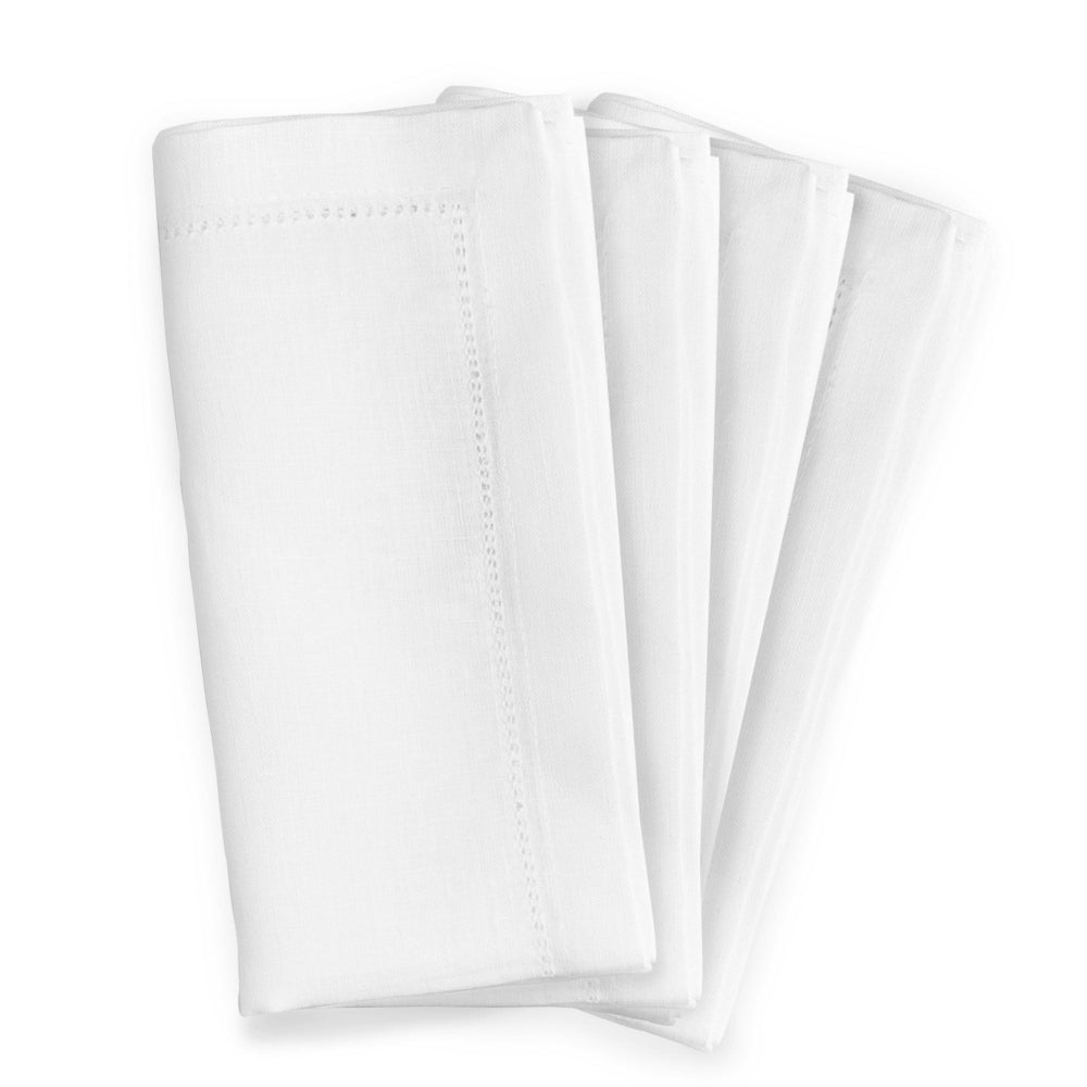 Four Folded Linen Hemstitched white napkins on a white background