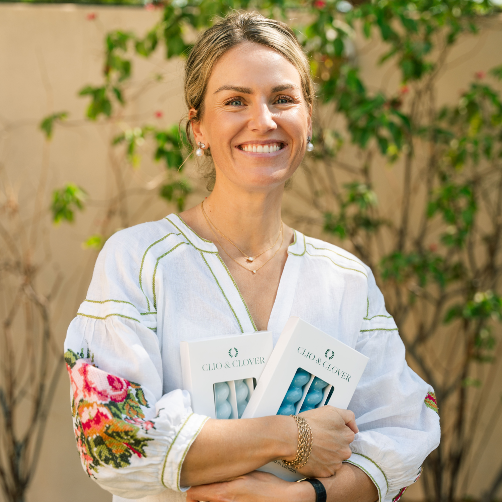 Woman holding two packs of 4 spiral gloss candles with a floral-patterned shirt outdoors