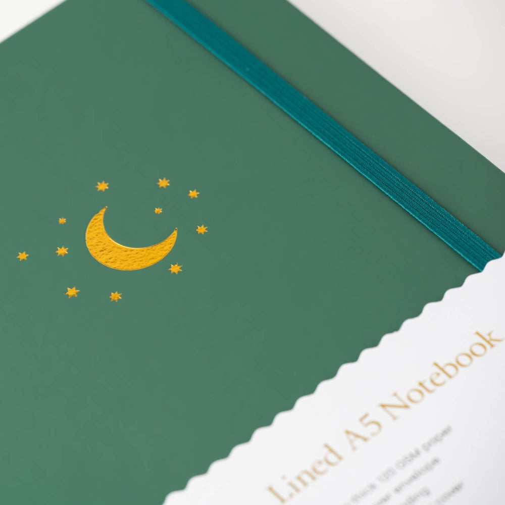 Forest Green notebook with gold moon and star design on a white background