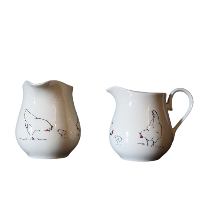 Two white ceramic pitchers with animal illustrations on a white background