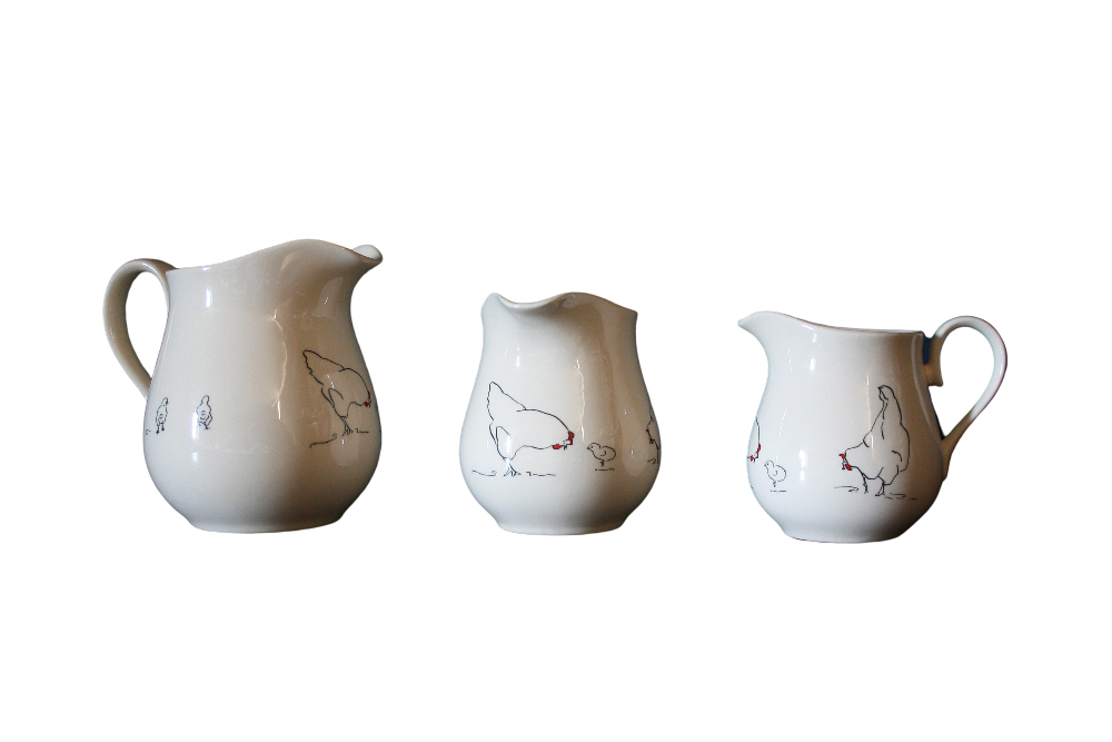 Three white ceramic pitchers with chicken illustrations on a white background