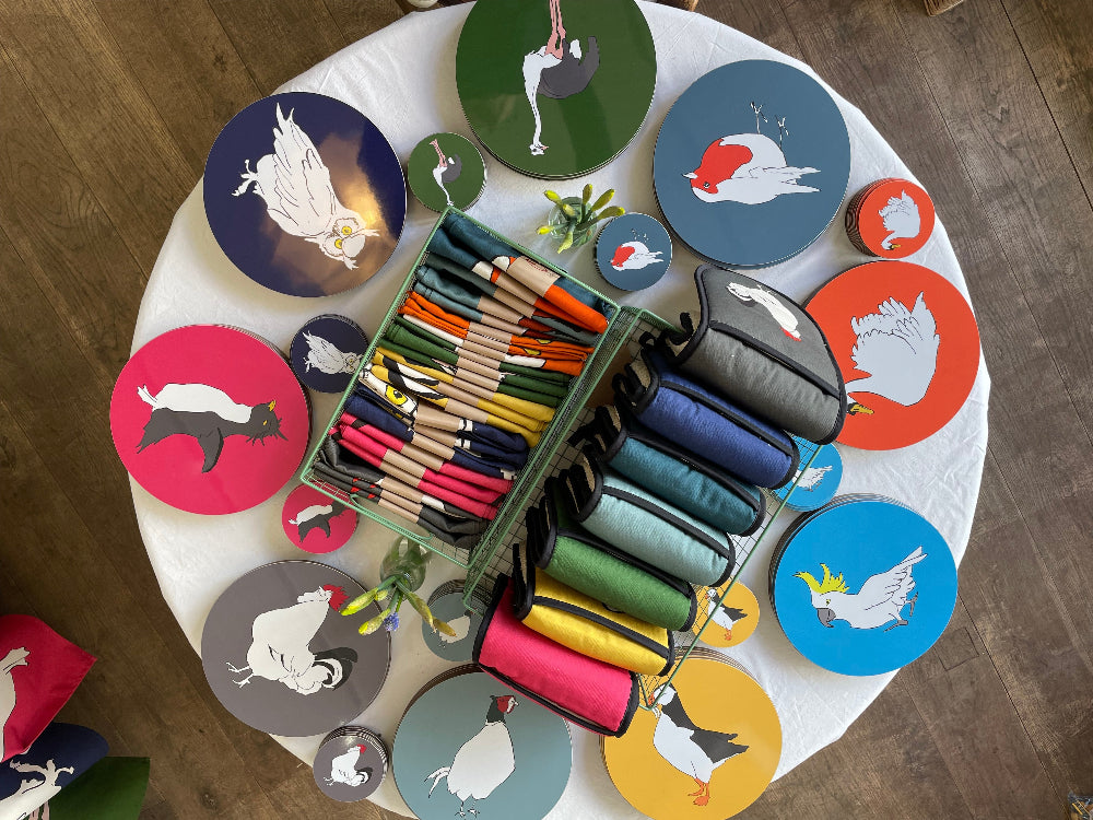 Colourful Placemats with bird illustrations on a table with matching coasters