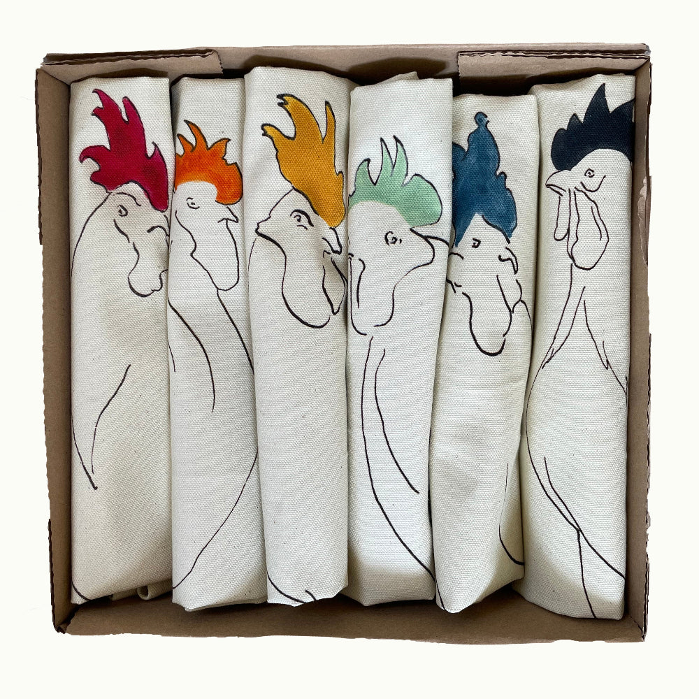Set of six fabric napkins with rooster designs in a cardboard box