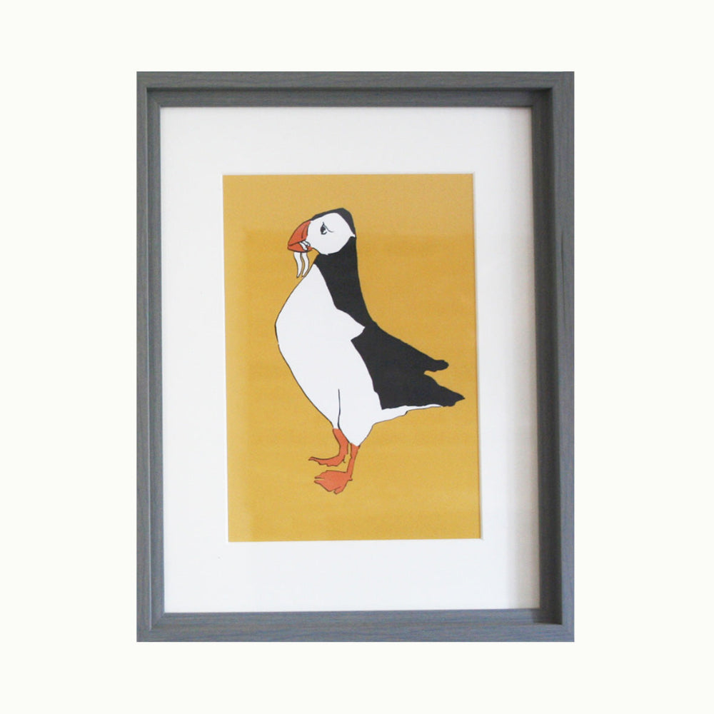 Framed artwork of a puffin on a yellow background
