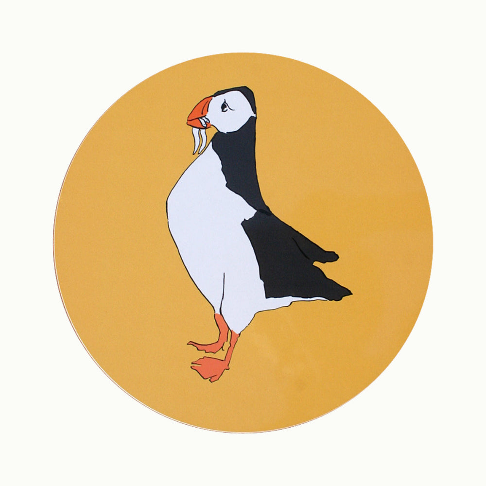 Illustration of a puffin on a yellow circle placemat on a white background
