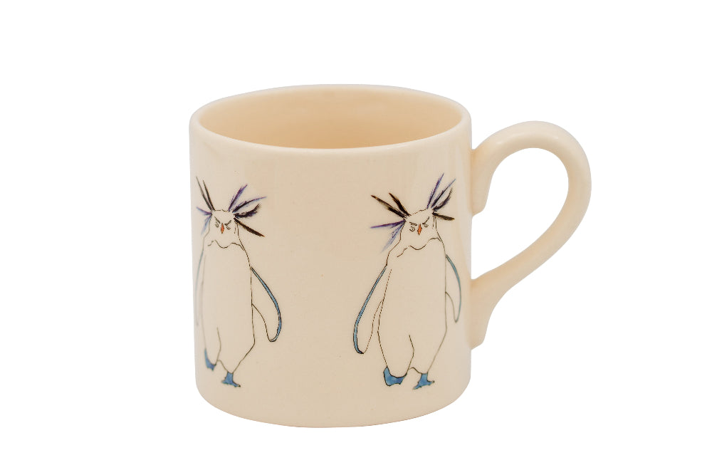 Beige mug with cartoon Rockhopper penguin design on a white background