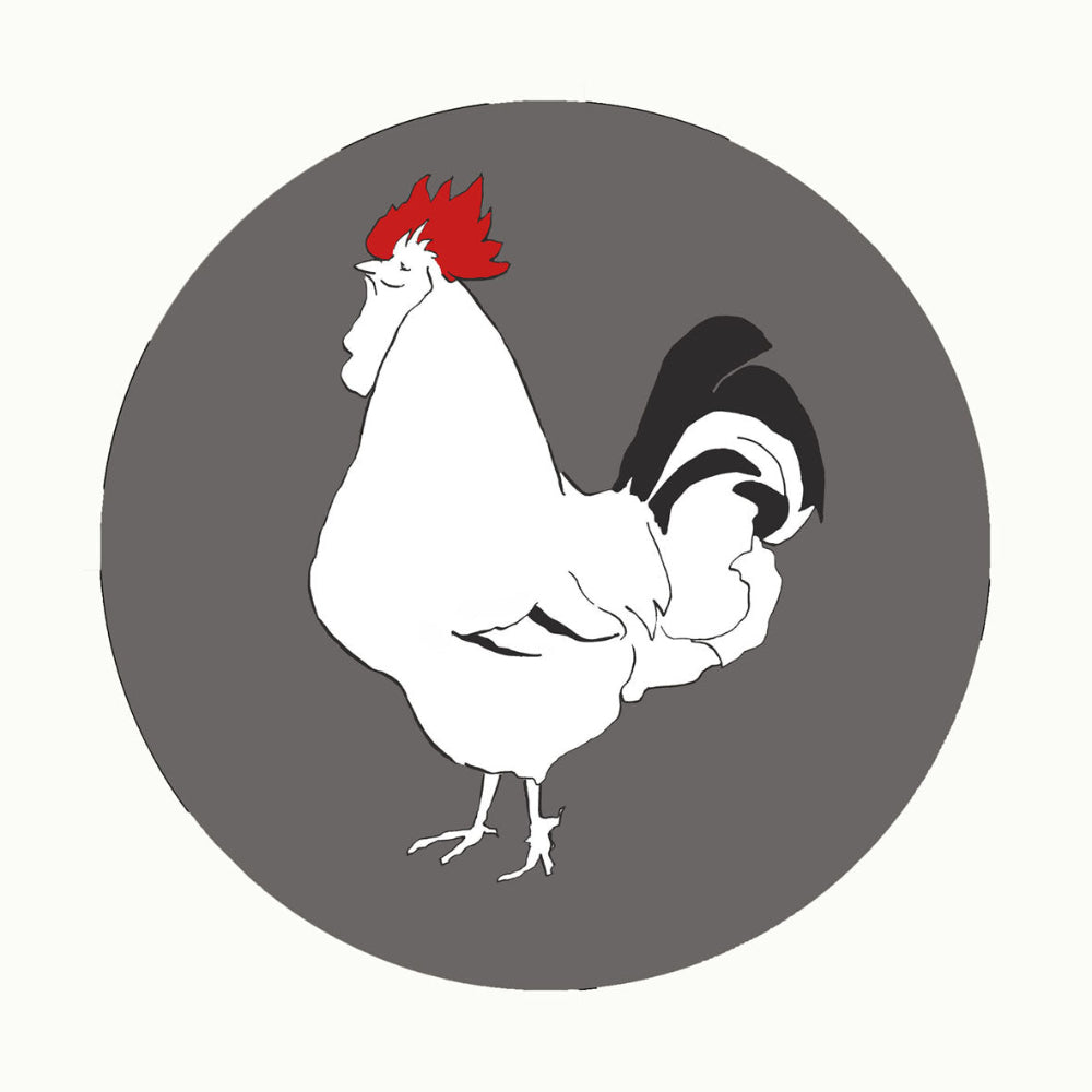 White rooster with a red comb on a grey circle placemat