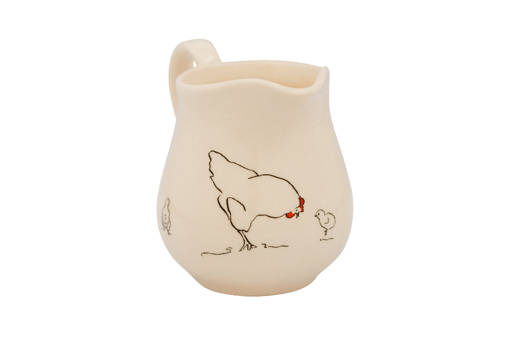 Ceramic pitcher with chicken design on a white background