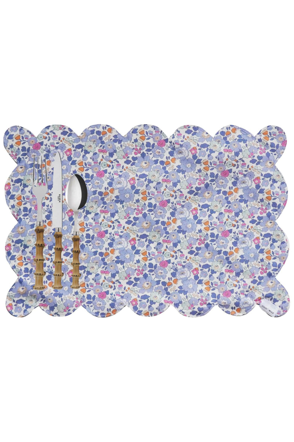 Floral patterned placemat Scalloped edge placemats with cutlery on a white background