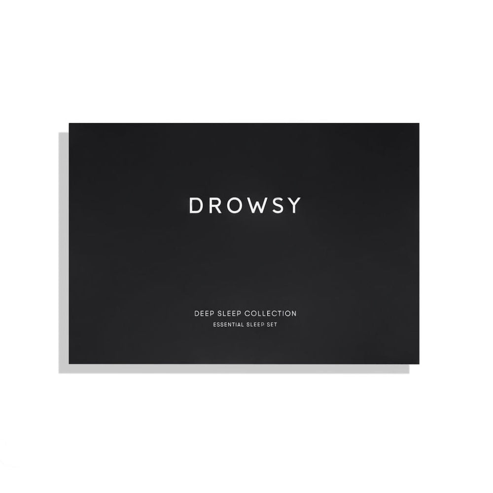 Black box with 'DROWSY' text on a white background. The Deep sleep collection essential sleep set including black silk eye mask, carry pouch and pillow mist.