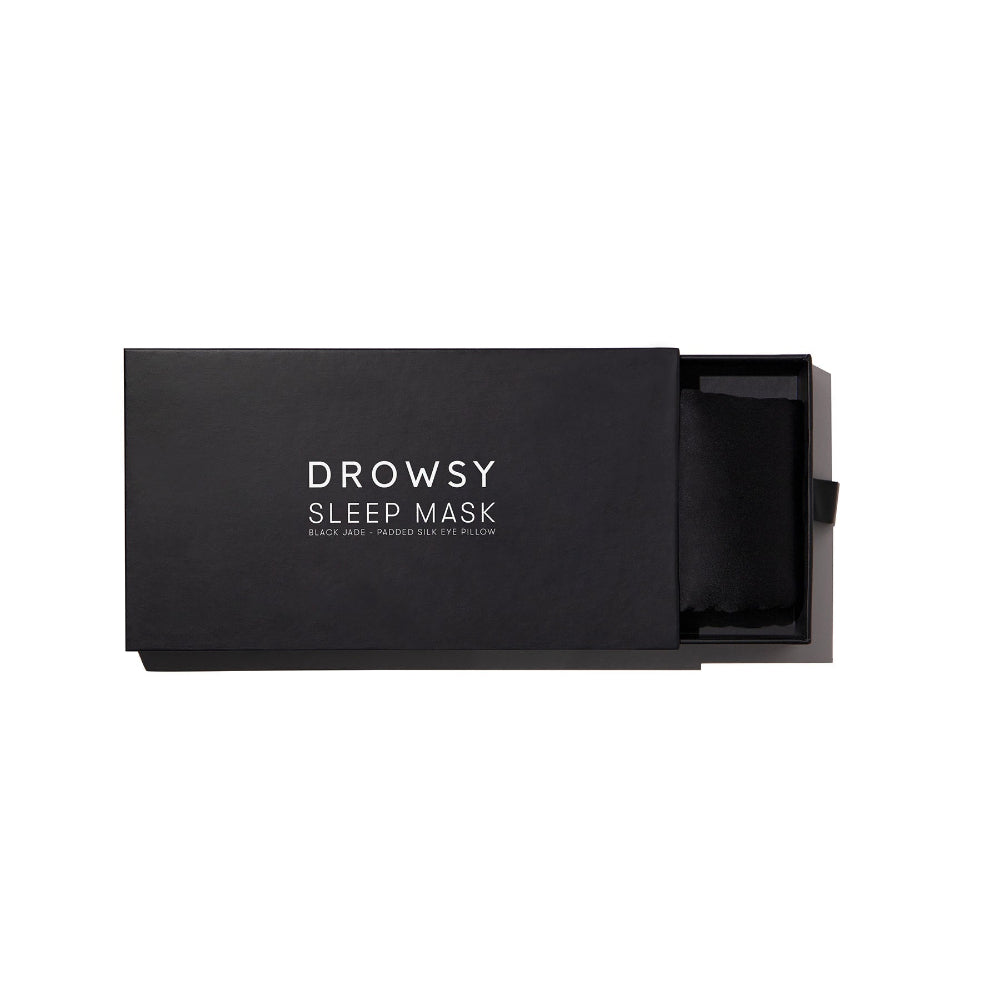 Black sleep mask in a box on a white background