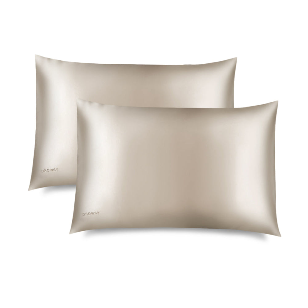 Two Drowsy Dusty Gold silk pillowcases on a white background