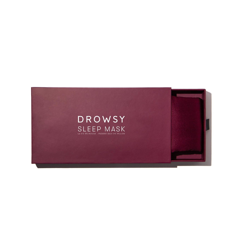 Maroon sleep mask in a box with branding on a white background