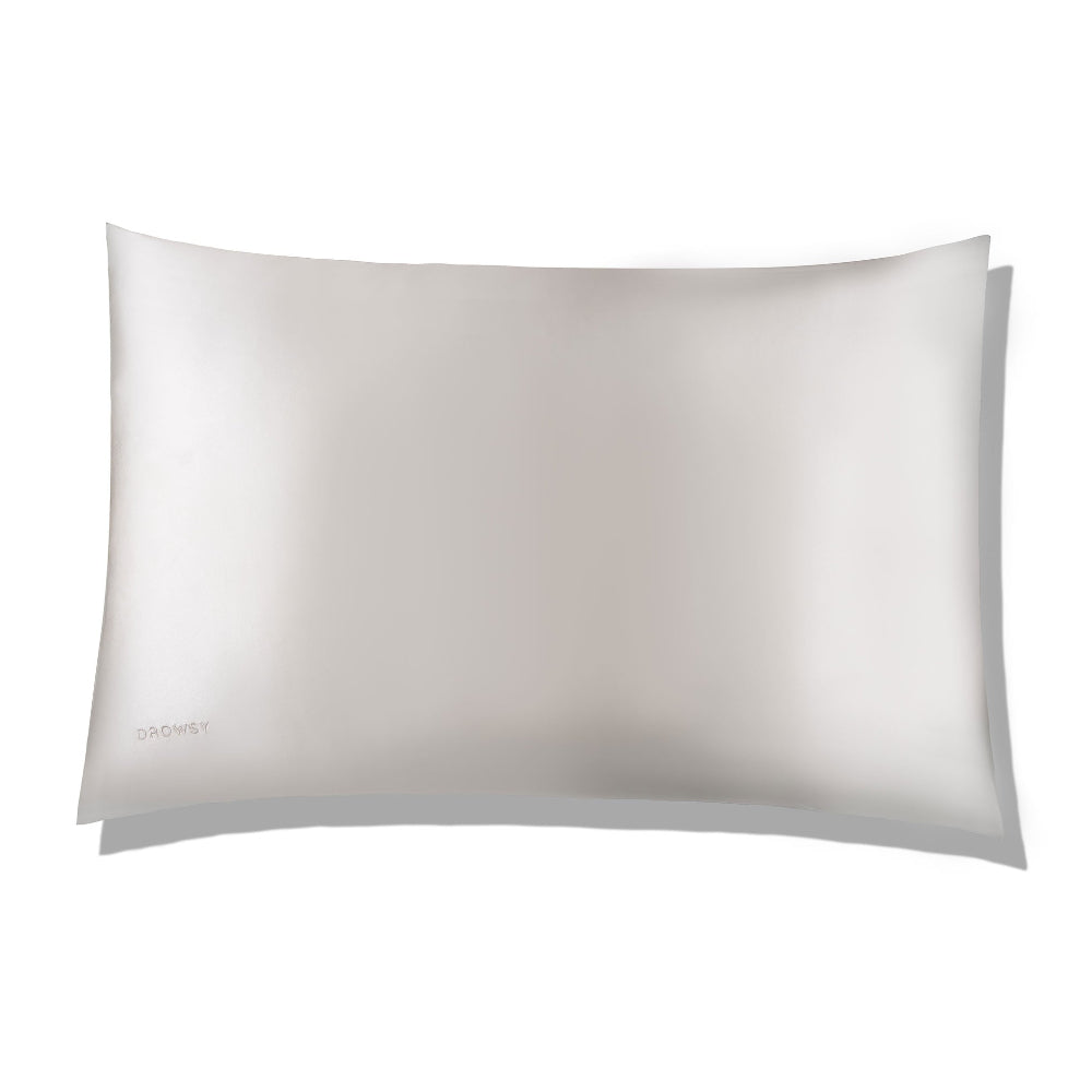 A white silk pillowcase with a smooth texture, presented in a relaxed, soft folding manner that highlights its luxurious and lightweight design.