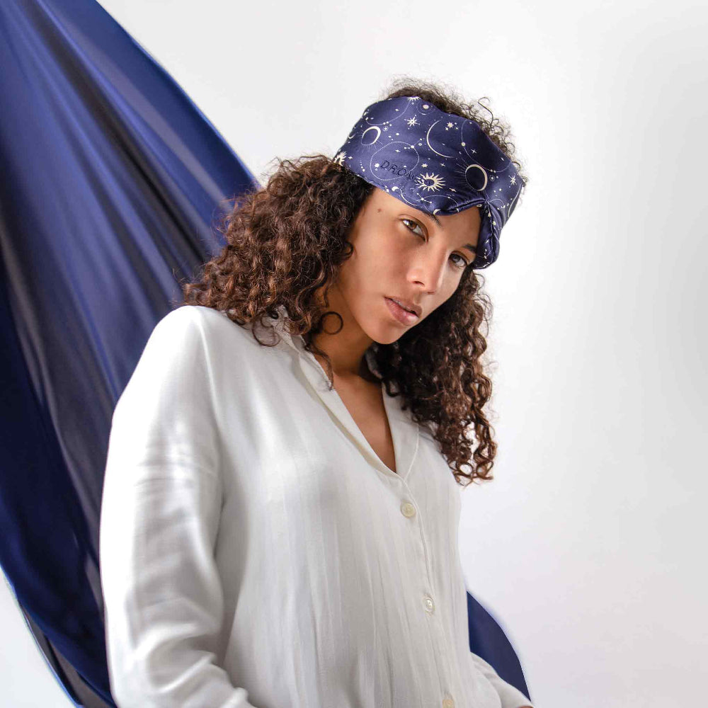 Woman wearing a blue Cosmic Energy Sleep mask with celestial design