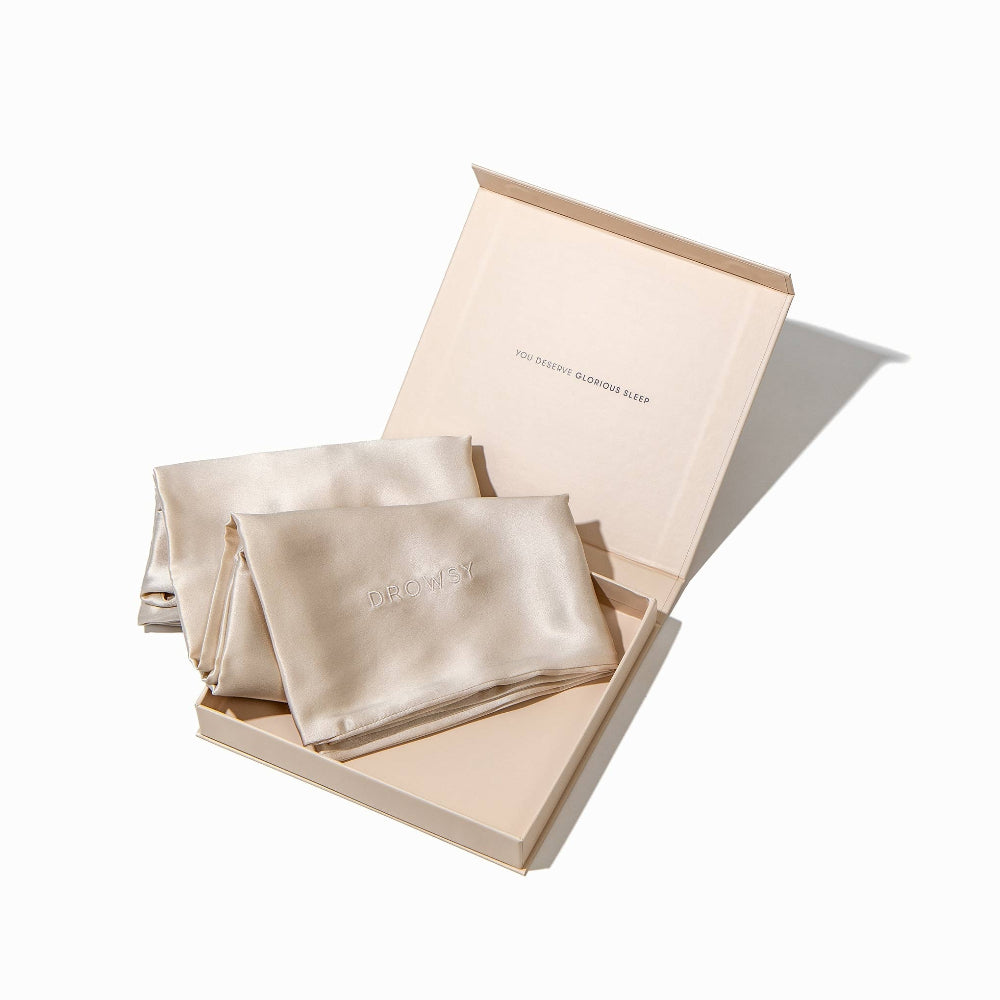 Silk Dusty Gold pillowcases in a branded box on a white background