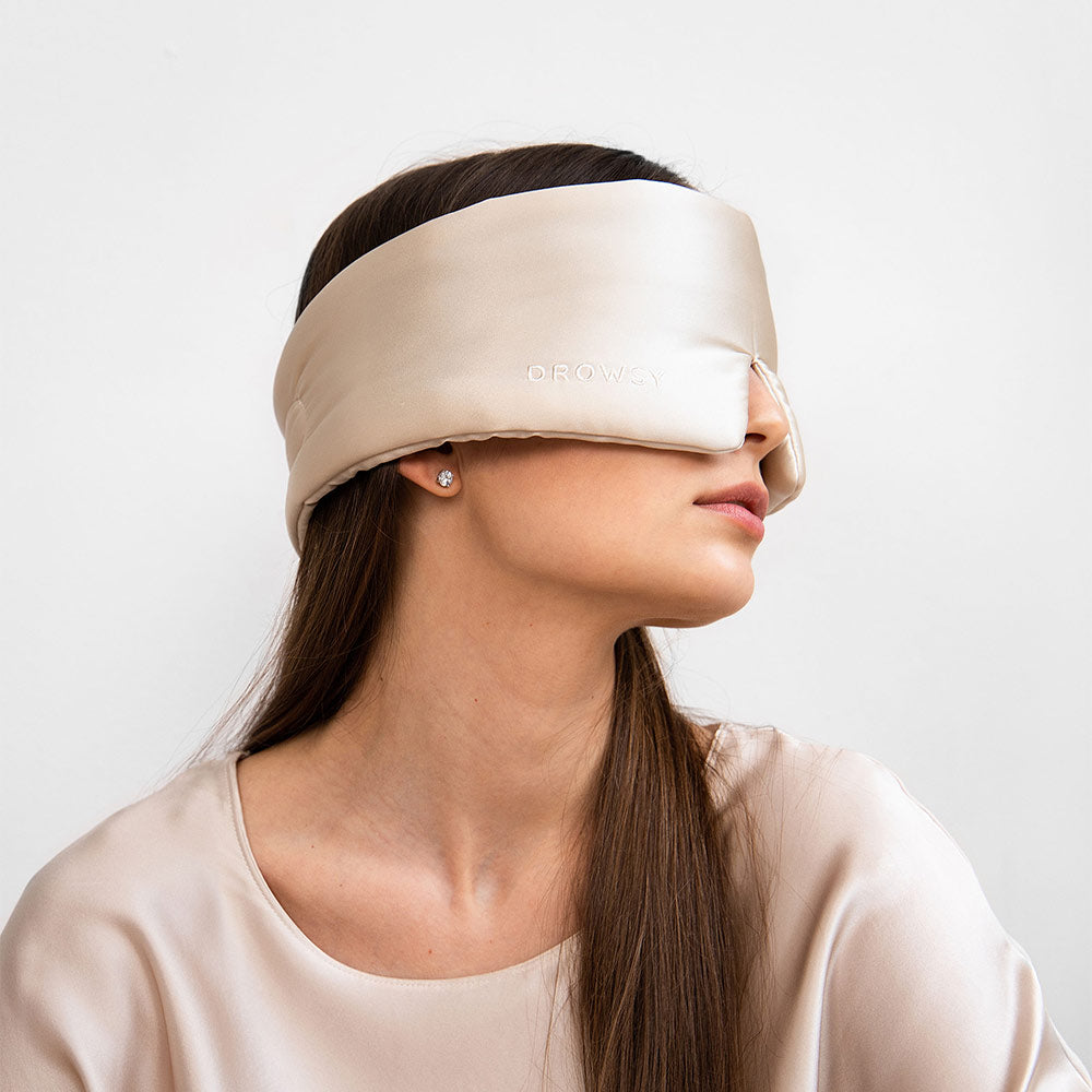 Person wearing a Dusty Gold silk sleep mask against a plain background