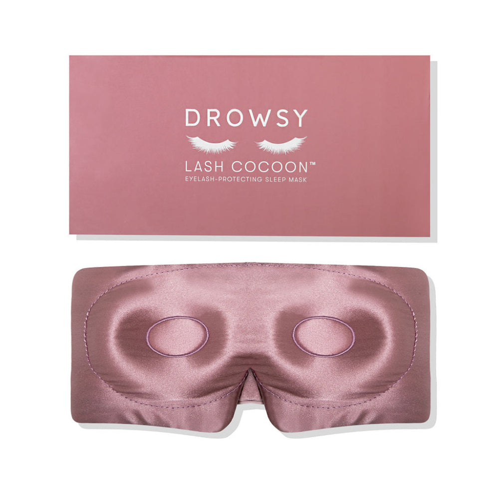 Pink sleep eye mask with matching pink coloured packaging on a white background