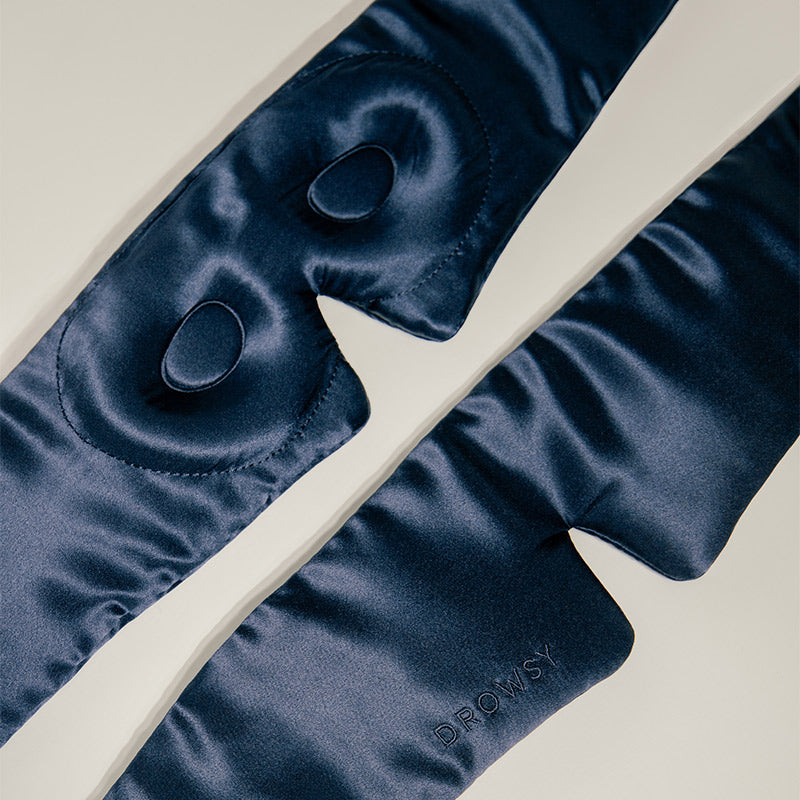 Dark blue satin eye mask on a light background
