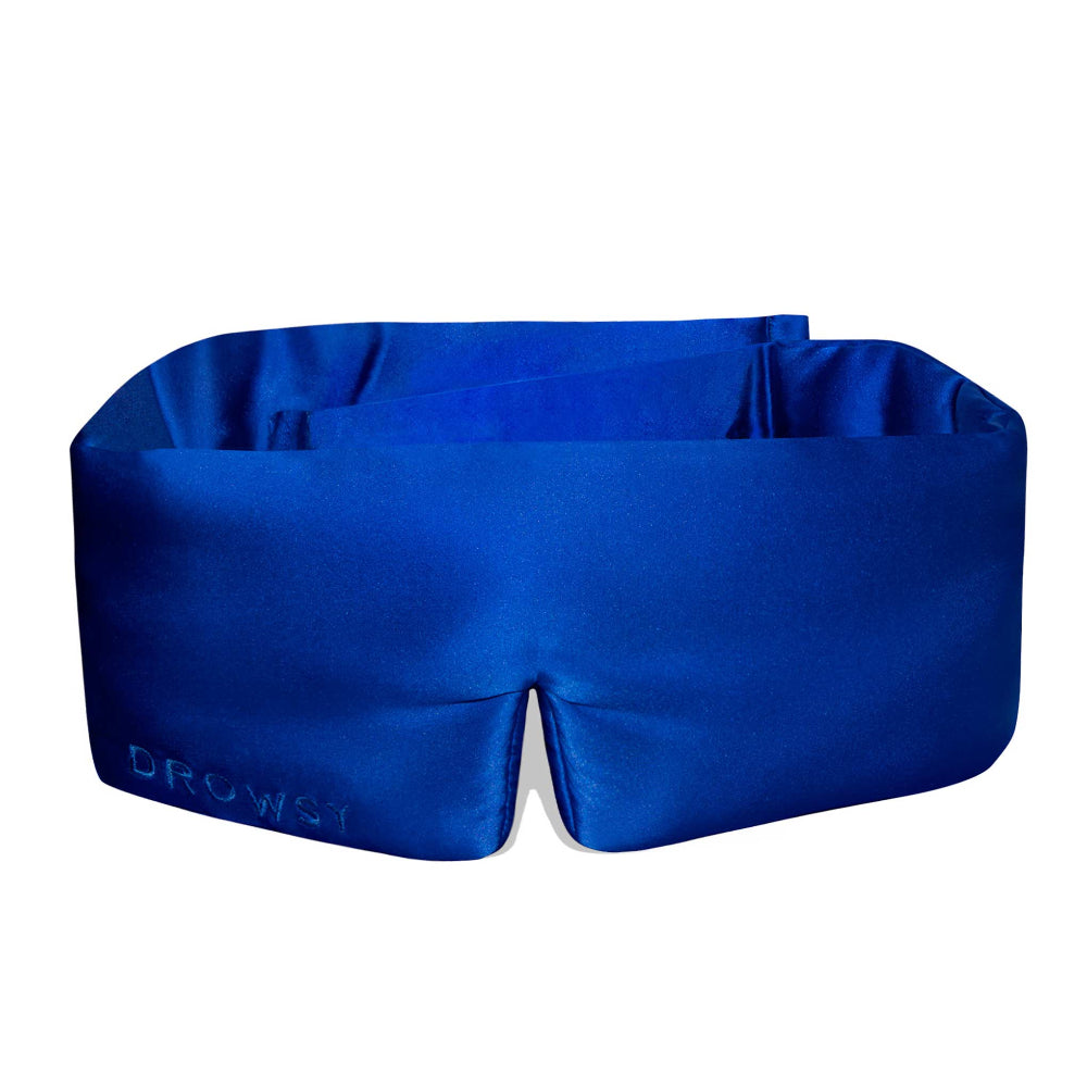 A royal blue silk sleep mask with a fully adjustable design, featuring a cloud-like padding.