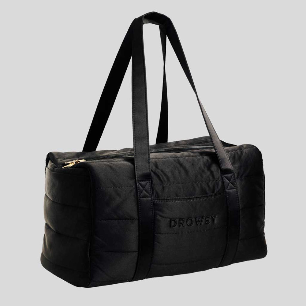 Black duffel bag with 'Drowsy' branding on a light grey background