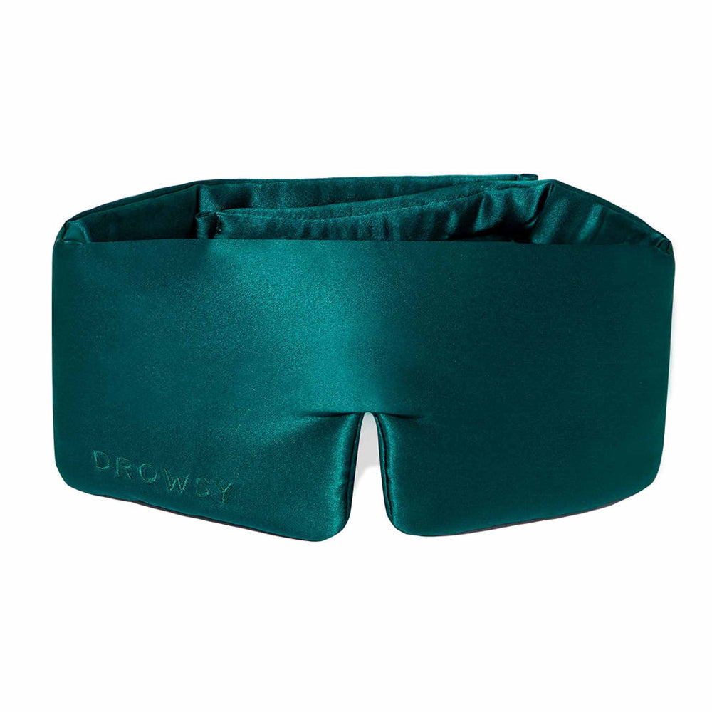 A green silk sleep mask with a cloud-like shape and the brand name 'DROWSY' visible on it.